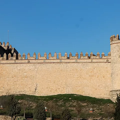 Fortaleza rectangular con torres en las esquinas y cielo despejado.