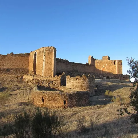 Vista exterior de fortaleza amurallada sobre terreno seco