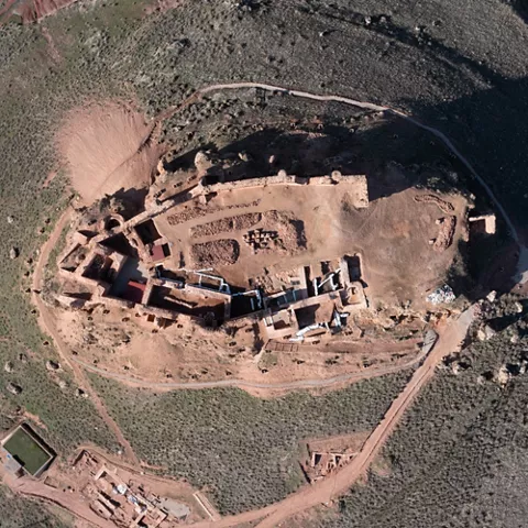Vista cenital de un yacimiento fortificado rodeado de caminos y terreno natural