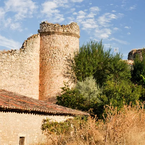 Murallas medievales con torres circulares al atardecer