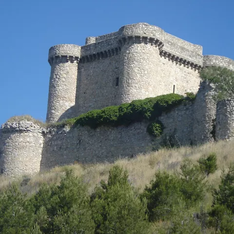 Detalle de castillo fortificado en ladera con vegetación baja