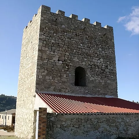 Torre fortificada con cubierta roja anexa.