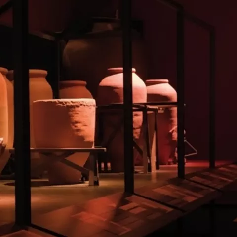 Interior con tinajas de cerámica de distintos tamaños en un espacio de museo.