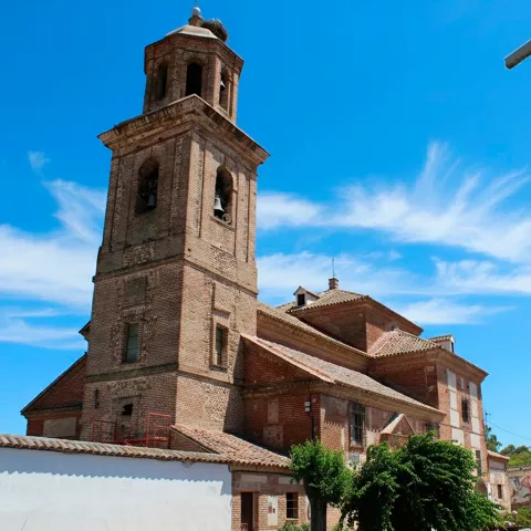 Vista lateral de iglesia con torre de ladrillo