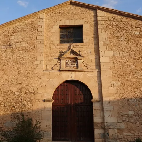 Fachada de iglesia de piedra, sobria y bien integrada en la trama del pueblo.