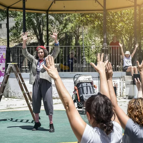 Actuación participativa en quiosco con público levantando las manos