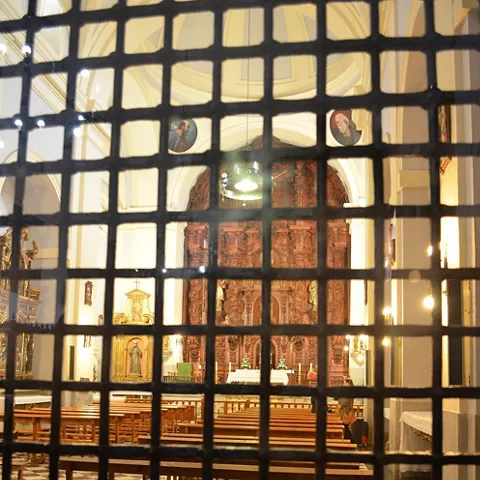 Nave de iglesia vista a través de una reja.