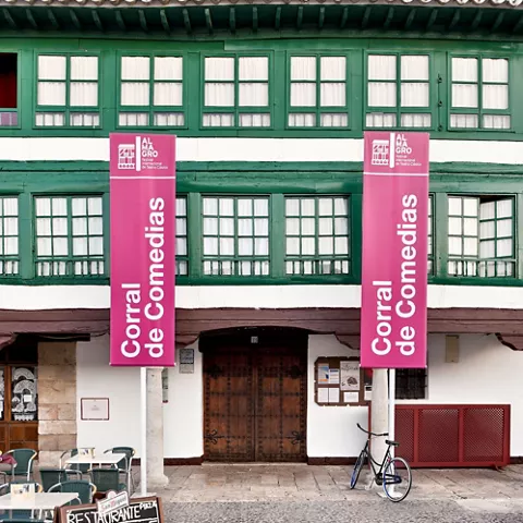 Fachada tradicional con balcones verdes y carteles verticales