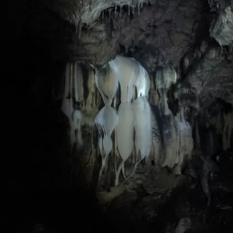 Estalactitas blancas en galería oscura