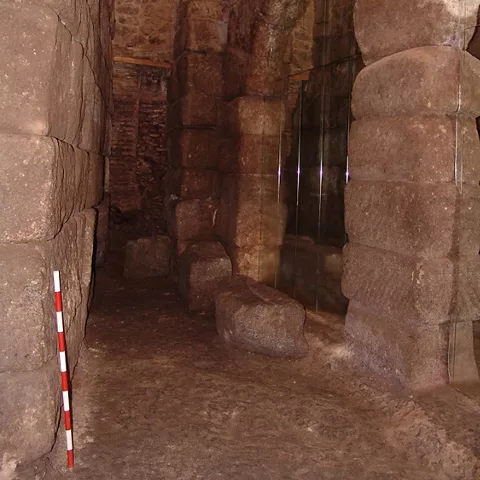Pasillo subterráneo con grandes sillares y pilares de piedra