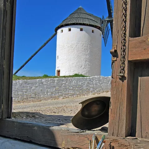 Vista exterior de molino desde interior con objetos artísticos
