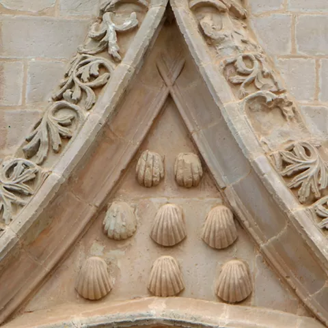 Detalle arquitectónico de fachada de iglesia con relieves ornamentales en piedra.