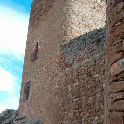 Muro de piedra con pequeñas ventanas.