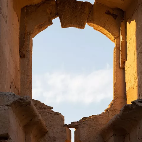 Ventana de piedra con arco en ruinas