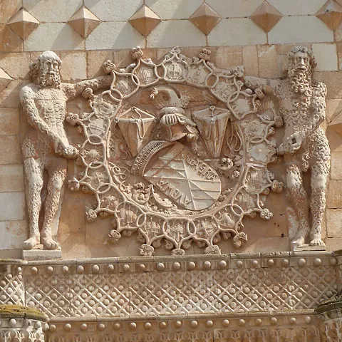 Escudo heráldico tallado en fachada histórica.