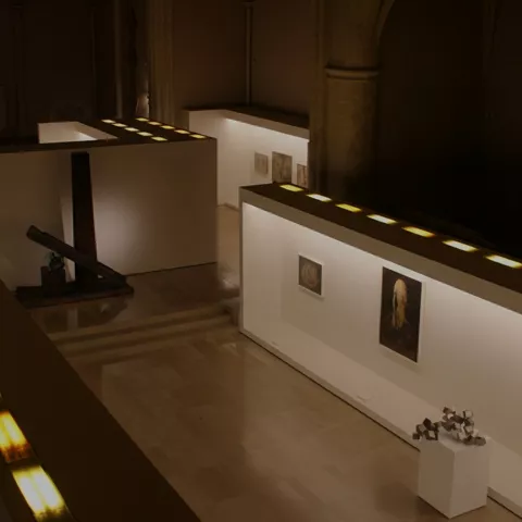 Vista elevada de sala con paneles blancos y luz cálida.