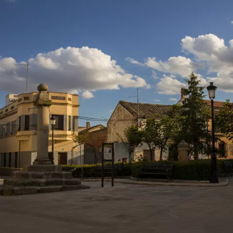Plaza con monumento de piedra y bancos