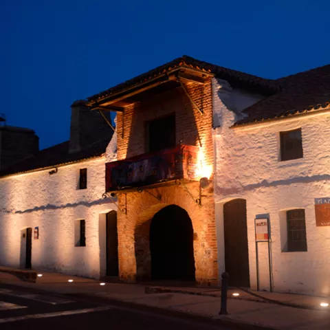 Fachada iluminada de plaza de toros al anochecer