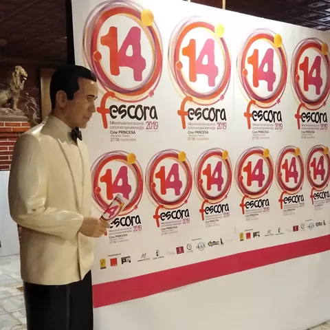 Figura con esmoquin junto a panel del festival