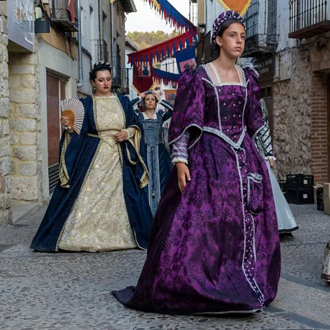 Desfile de trajes renacentistas en calle histórica.