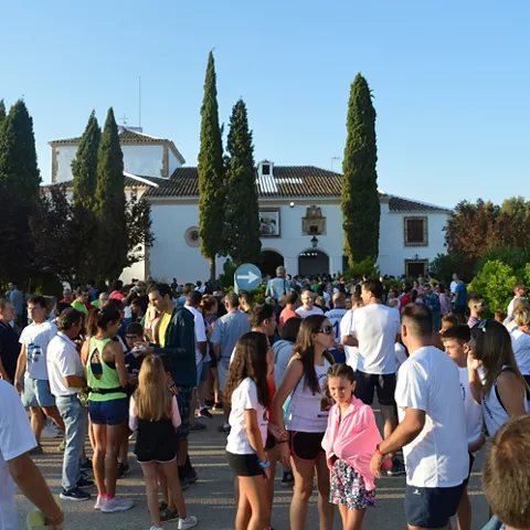 Gran concentración de personas frente a un edificio blanco en un día soleado.