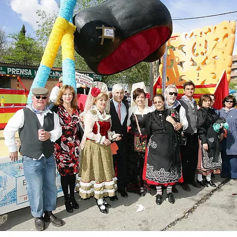 Grupo con trajes tradicionales junto a una carroza