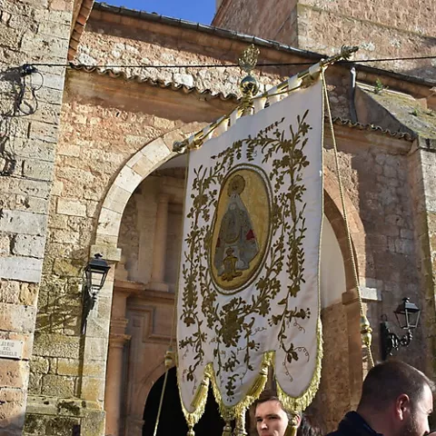 Estandarte bordado frente a la fachada de piedra de una iglesia