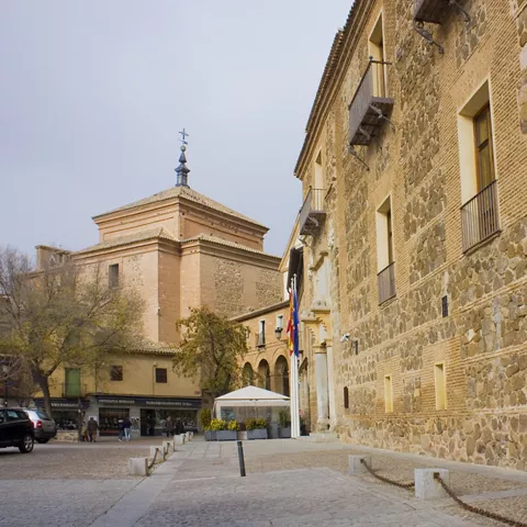 Calle empedrada junto a edificio de piedra y ladrillo