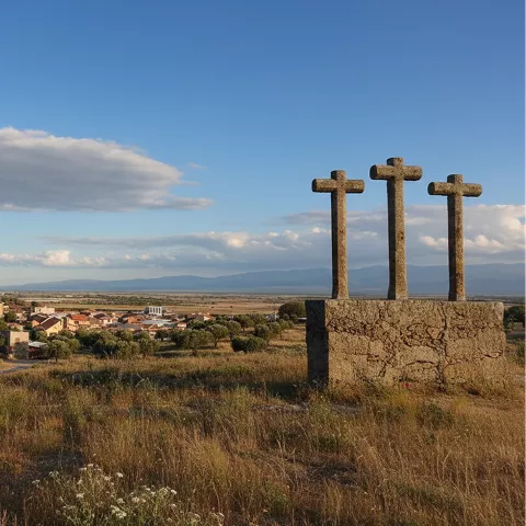 Cruces de piedra sobre colina con vista del pueblo