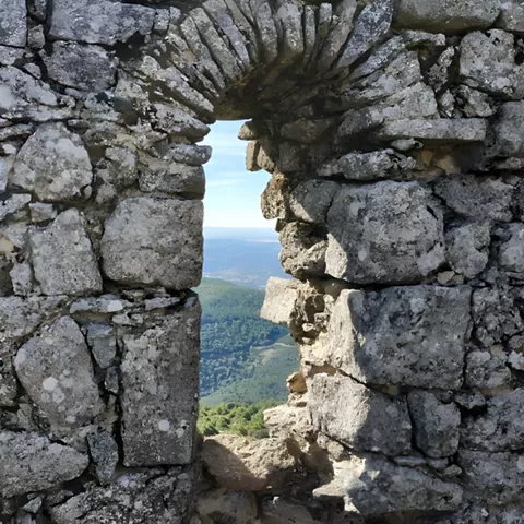Ventana de piedra en ruina con paisaje al fondo