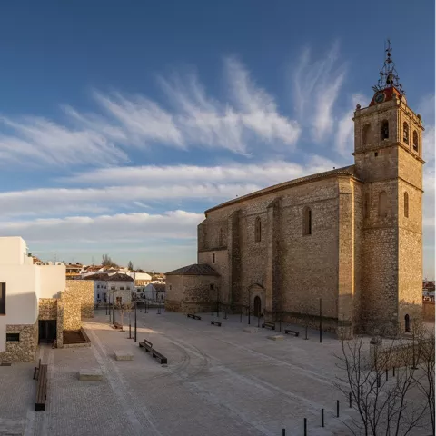 Vista urbana con iglesia de piedra y plaza despejada