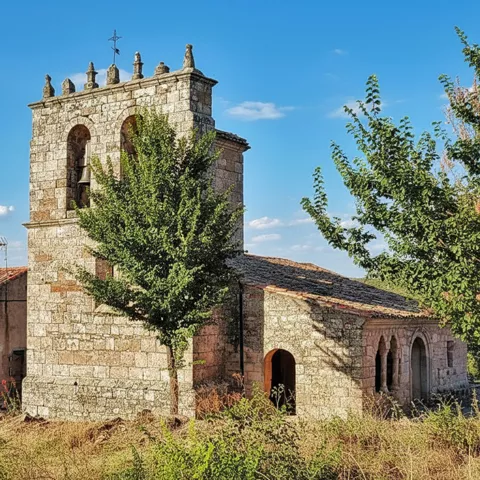 Vista lateral de iglesia de piedra entre vegetación.