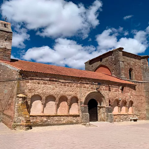 Iglesia románica con torre y espadaña.