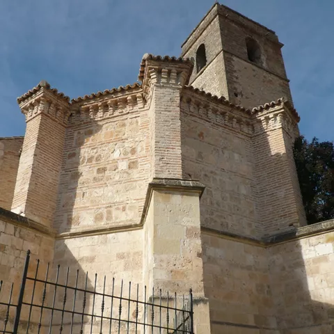 Torre y ábside con fábrica de ladrillo y piedra.