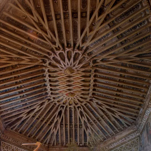 Artesonado de madera tallada con estructura geométrica decorada.