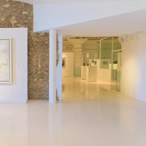 Sala moderna con cuadro abstracto y muro de piedra vista.