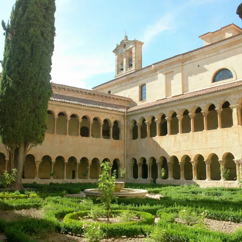 Claustro luminoso con fuente y vegetación.