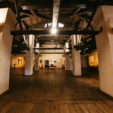 Interior amplio con columnas, tarima de madera y luz cenital