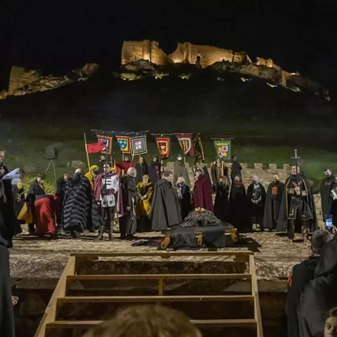 Escena nocturna de recreación medieval ante fortaleza