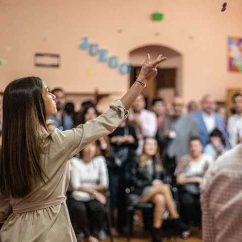 Público siguiendo un juego tradicional en sala cerrada