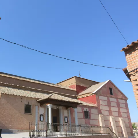 Iglesia de ladrillo con alta torre campanario