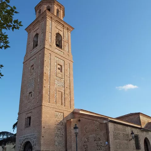 Iglesia de ladrillo con torre campanario alta