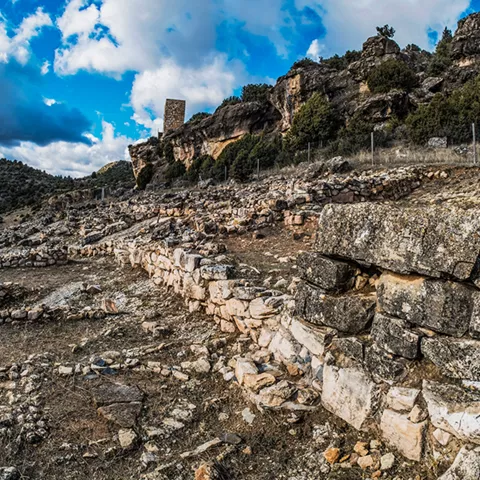 Estructuras de piedra junto a pared rocosa