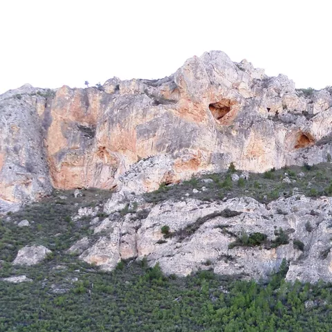 Acantilado de roca caliza con cavidades naturales en la pared.