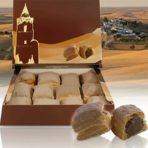 Caja abierta con dulces espolvoreados y dos piezas partidas mostrando el relleno.