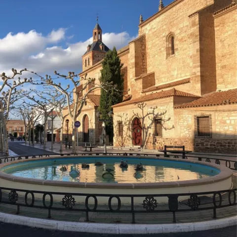 Fuente circular en plaza junto a iglesia histórica