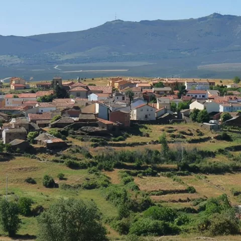Vista del pueblo entre montañas y campos.