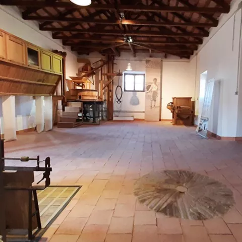 Sala histórica con herramientas tradicionales y piedra de molino