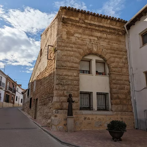 Edificio histórico de piedra en una calle tranquila.