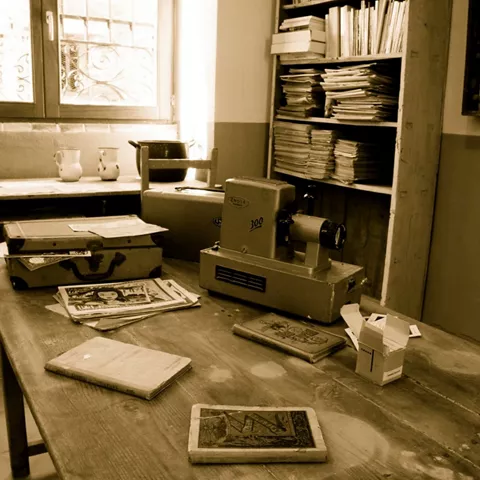 Mesa con libros y proyector escolar antiguo.